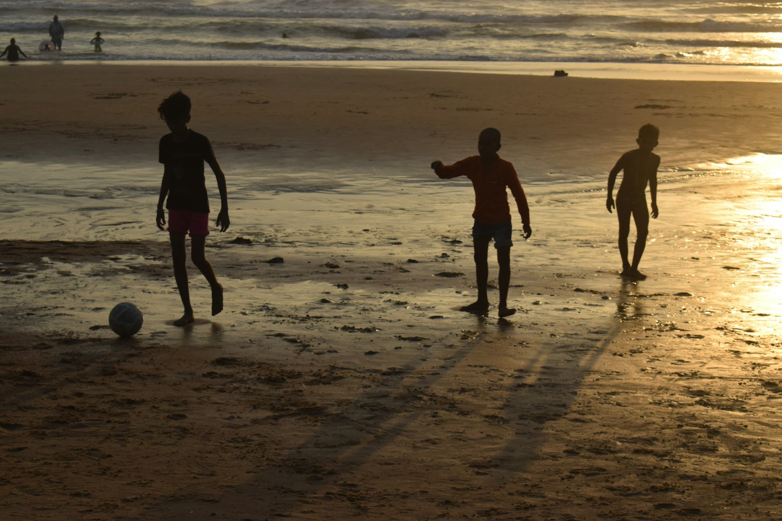 秋冬に自主練が続かない子|日が短くなる時期の仕組みづくり 夕暮れの中でサッカーをする子供たち。秋は日が短くなり外での自主練が難しくなる
