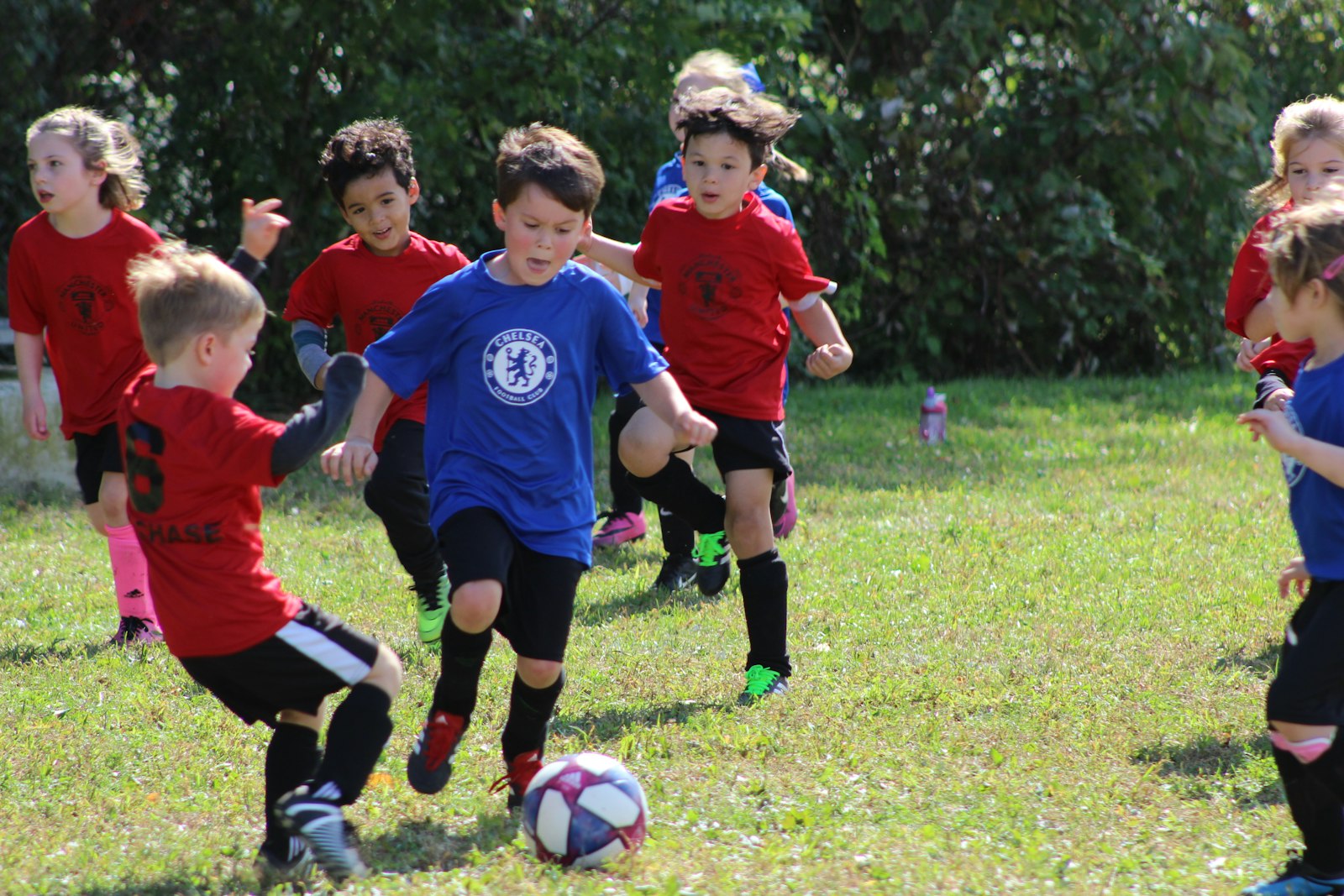 夕方のグラウンドでボールを蹴る少年サッカー選手