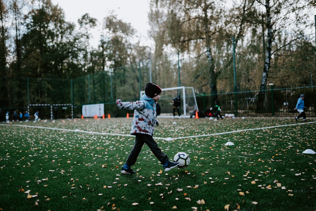 秋の公園でスポーツをする子供