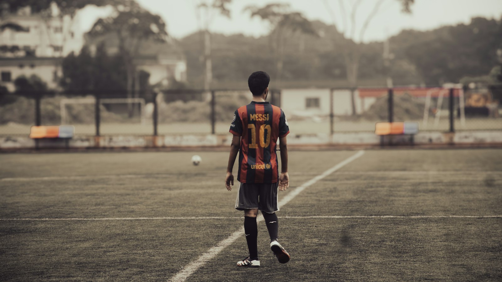 グラウンドに一人で立つ少年サッカー選手