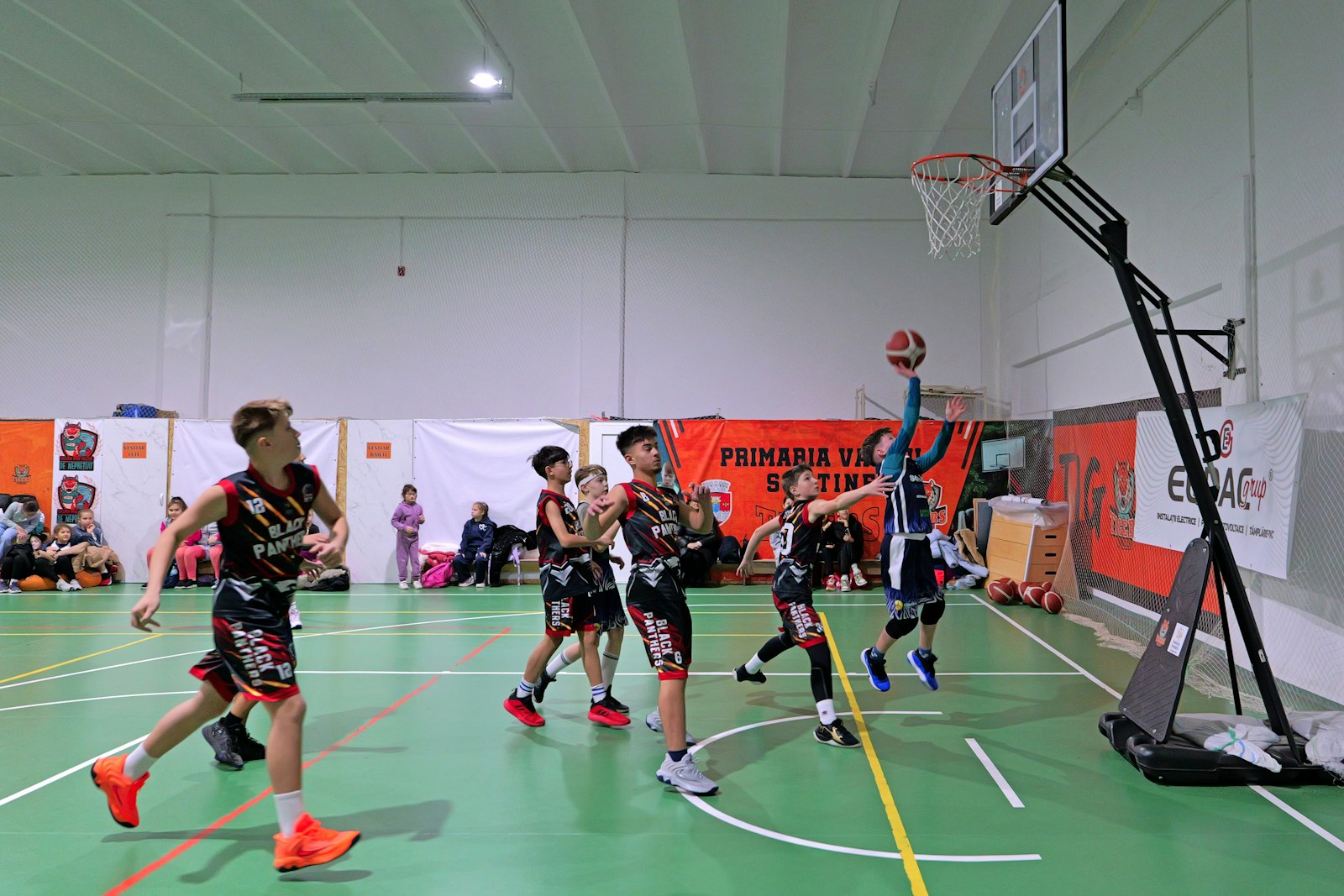 屋内コートでプレーする少年バスケットボール選手たち