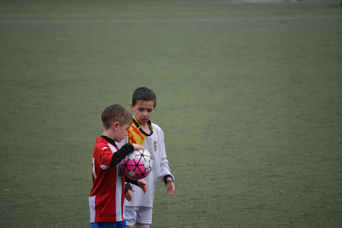 試合前にグラウンドでサッカーボールを持つ少年
