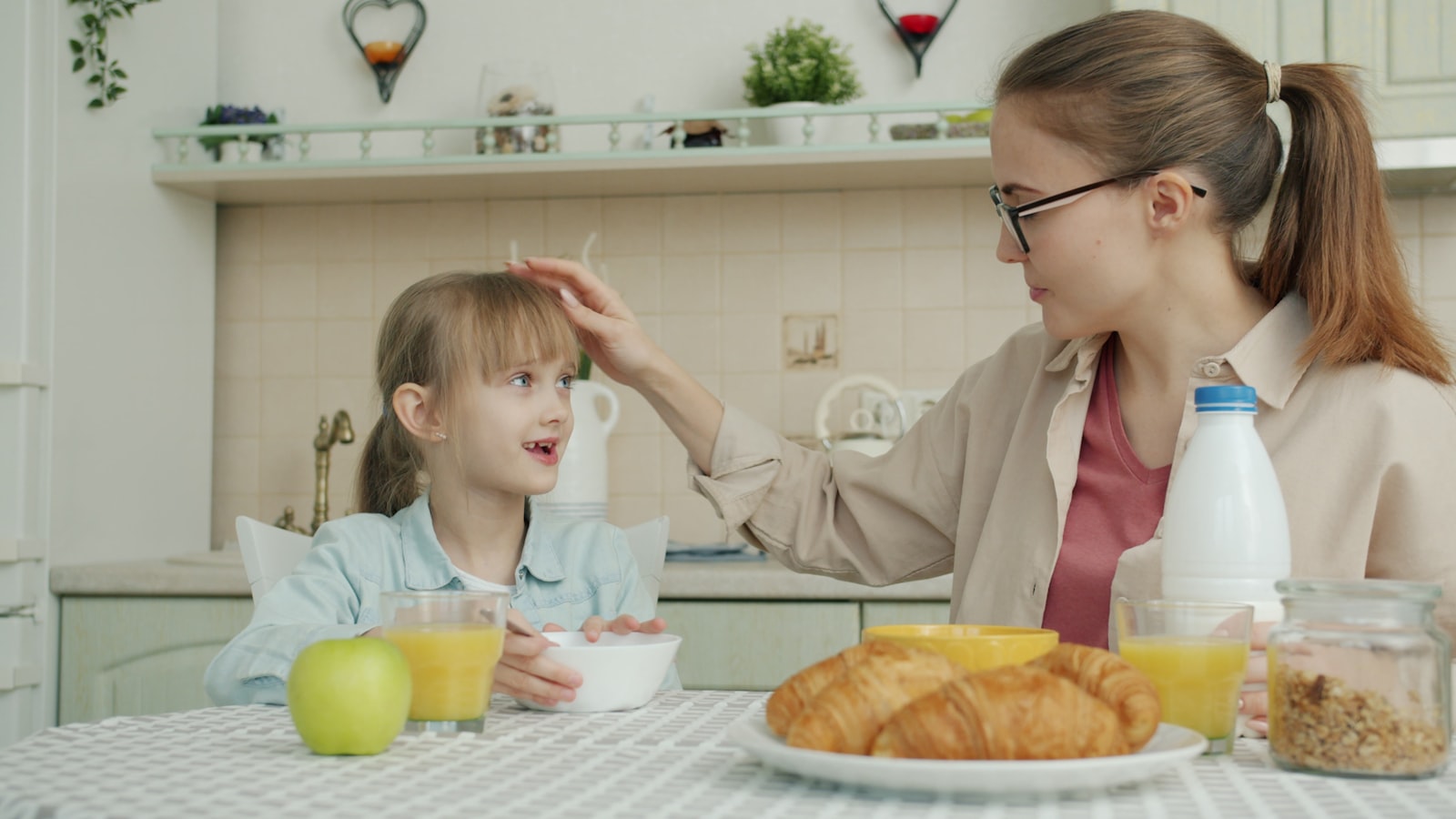 朝食の食卓で子どもと話す保護者